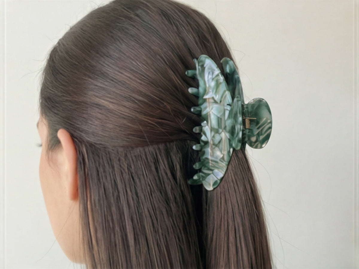 Person with a decorative hair clip in their hair against a plain background